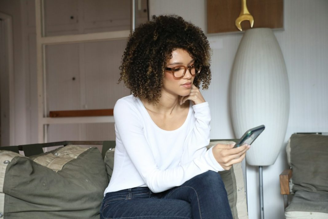 Truffa WhatsApp vota la bambina: donna che legge un messaggio sospetto sullo smartphone